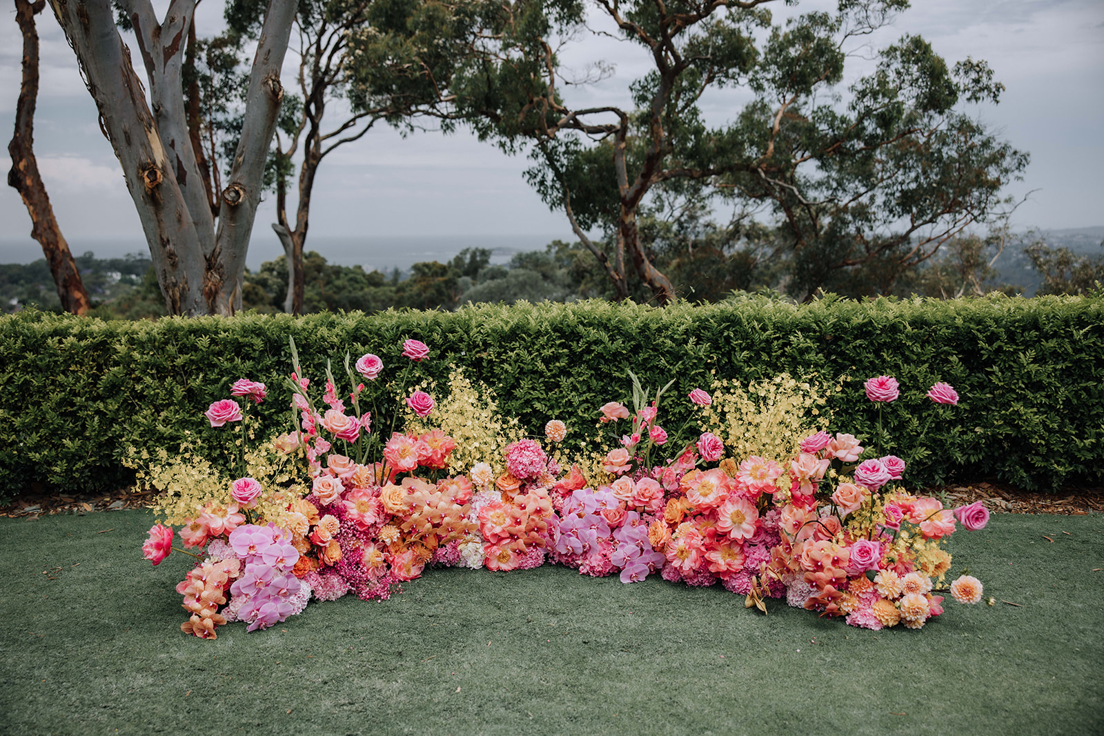 Statement ceremony installation — a ground floral nest overlooking the water